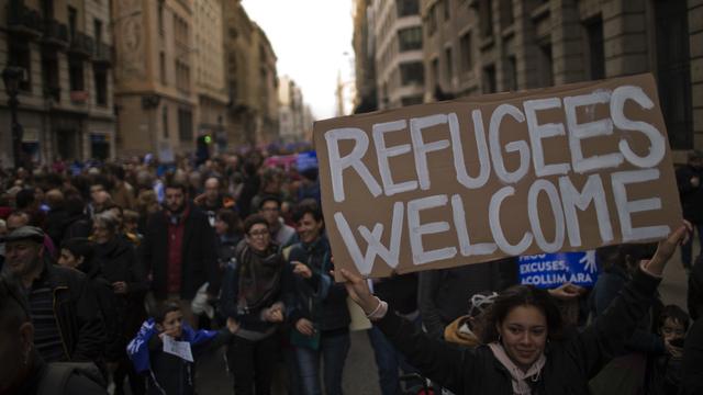 Des manifestants défilent dans les rues de Barcelone en faveur des réfugiés. [Keystone - Emilio Morenatti]