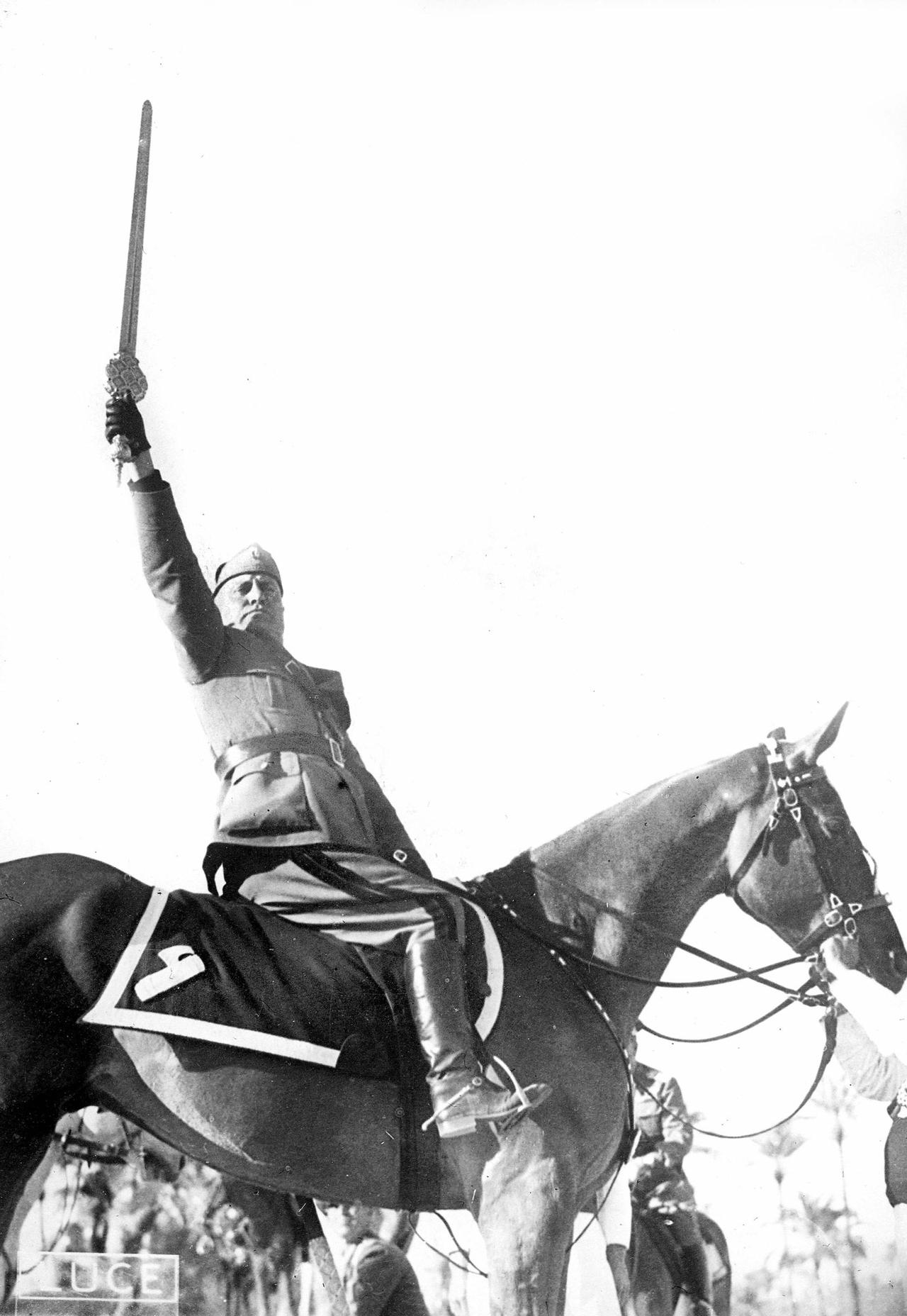 Benito Mussolini pose fièrement sur son cheval. Sur d'autres photos, le palefrenier qui tient la monture a été effacé. [AFP]