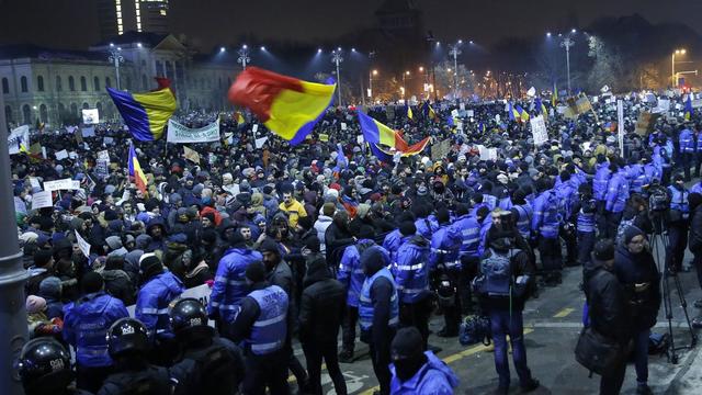 Des manifestants font face à la police devant le siège du gouvernement à Bucarest le 1er février 2017. [Keystone - EPA/ROBERT GHEMENT]