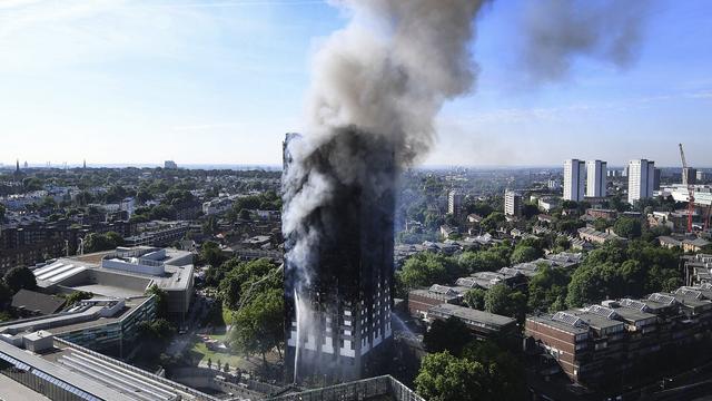 Une épaisse fumée s'élevait toujours de le ciel mercredi matin suite à l'incendie qui a frappé une tour d'habitation à l'ouest de Londres. [Keystone - Andy Rain/EPA]