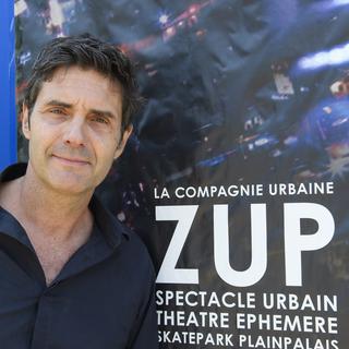 Le comedien Laurent Deshusses devant l'affiche du spectacle ZUP. [Keystone - Martial Trezzini]
