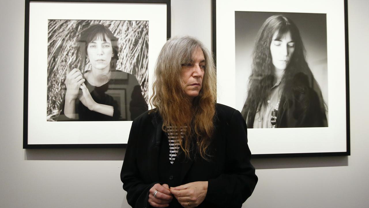 La chanteuse Patti Smith devant deux de ses portraits réalisés par le photographe Robert Mapplethorpe, lors d'une exposition au Grand Palais à Paris en mars 2014. [PATRICK KOVARIK]