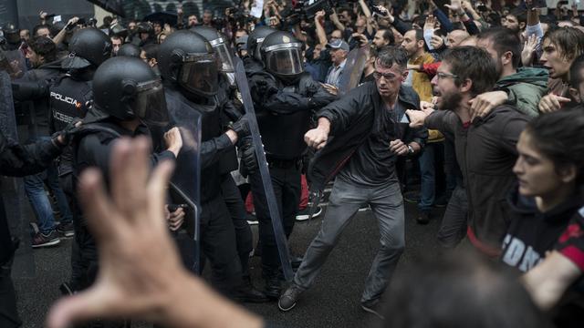 Des manifestants face à la police à Barcelone. [AP/Keystone - Felipe Dana]