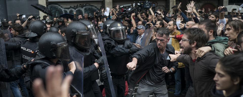 Des manifestants face à la police à Barcelone. [AP/Keystone - Felipe Dana]