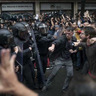 Des manifestants face à la police à Barcelone. [AP/Keystone - Felipe Dana]
