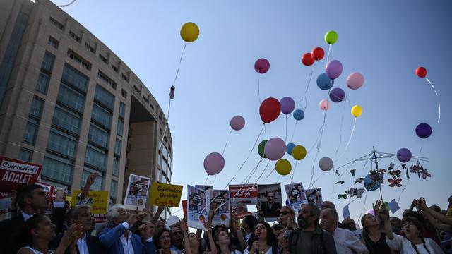 De nombreuses personnes, dont des journalistes et des députés de l'opposition, se sont rassemblées lundi matin devant le tribunal en soutien aux accusés, et ont procédé à un lâcher de ballons. [AFP - Ozan Kose]