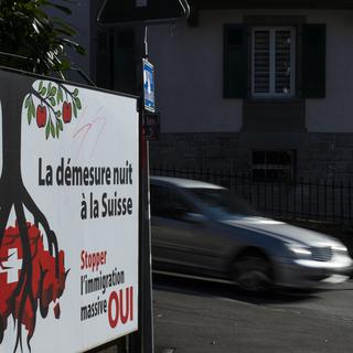 Affiche de l'UDC invitant à voter pour l'initiative populaire "contre l'immigration de masse" le 9 février 2014. [Keystone - Jean-Christophe Bott]