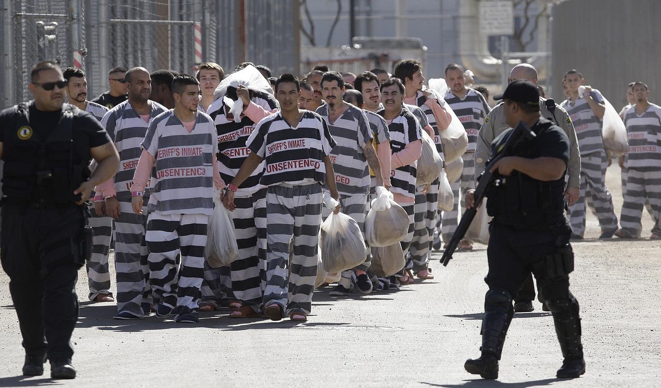 Quelques 200 migrants illégaux menottés les uns aux autres dans une prison de Phoenix, en Arizona. [Keystone - Ross D. Franklin]