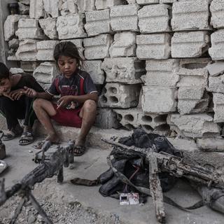 Des enfants syriens à côté d'armes prises au groupe Etat islamique. [AFP - Yasin Akgul]