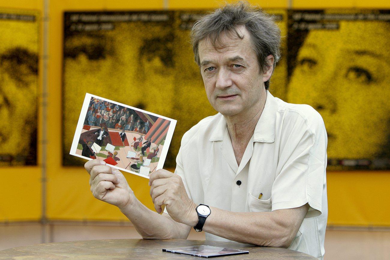 Le cinéaste suisse d'animation Georges Schwizgebel, avec une image issue de son film "Jeu", lors du 59e Festival de Locarno en 2006. [Keystone - Martial Trezzini]