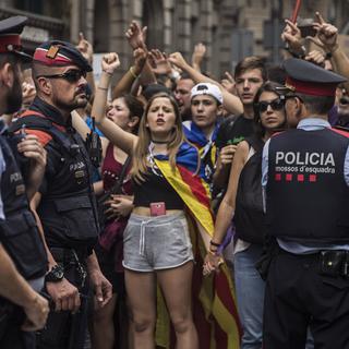 Des manifestants encadrés par la police catalane mardi lors de la grève générale. [AP Photo/Keystone - Santi Palacios]