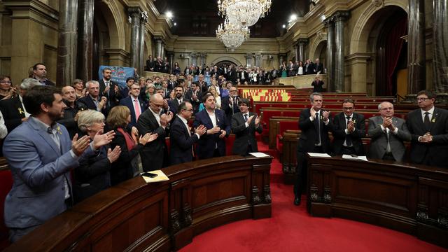 Le président de l'exécutif catalan Carles Puigdemont (au centre) et les députés régionaux applaudissent l'adoption de la motion. [Reuters - Albert Gea]