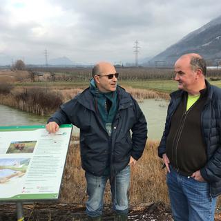 Beat Oertli, biologiste (gauche) et Pierre-André Frossard, spécialiste de la restauration des milieux naturels (droite), tous deux professeurs à l’HEPIA, Genève devant le bas-marais de Chamoson-Ardon, en Valais. [RTS - Yves Terrani]