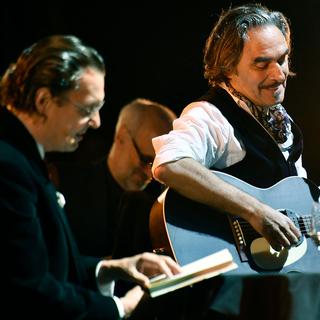 Stephan Eicher (à droite) et l'écrivain Martin Suter lors d'un concert à Zurich le 8 juillet 2017. [Keystone - Walter Bieri]