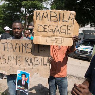 Des opposants au président Joseph Kabila brandissent des pancartes aux messages explicites à Kinshasa. [AFP - Junior Kannah]