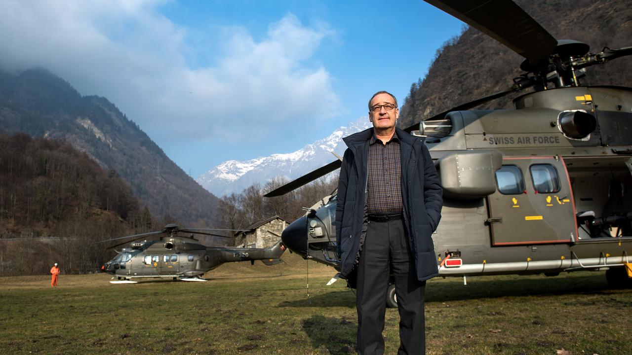 Le conseiller fédéral Guy Parmelin devant un Super Puma des Forces aériennes suisses dans les Grisons en décembre 2016. [Keystone - Ti-Press/Gabriele Putzu]