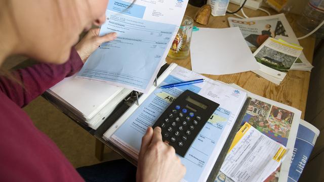 Une femme payant ses primes d'assurance maladie. [Keystone - Martin Rütschi]