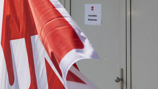 Un drapeau du syndicat Unia sur le site du fabricant de matériel ferroviaire Bombardier à Villeneuve (VD). [Keystone - Jean-Christophe Bott]