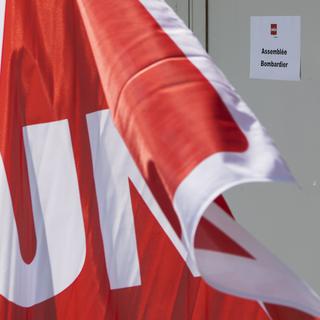 Un drapeau du syndicat Unia sur le site du fabricant de matériel ferroviaire Bombardier à Villeneuve (VD). [Keystone - Jean-Christophe Bott]