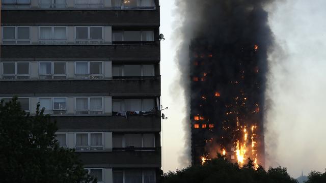 De la fumée et des flammes s'élèvent de cette tour d'habitation située dans l'ouest de Londres. [Keystone - Matt Dunham/AP]