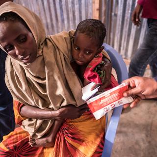 Une femme et son enfant reçoivent des vivres en Somalie (image prétexte). [NurPhoto/afp - Maciej Moskwa]