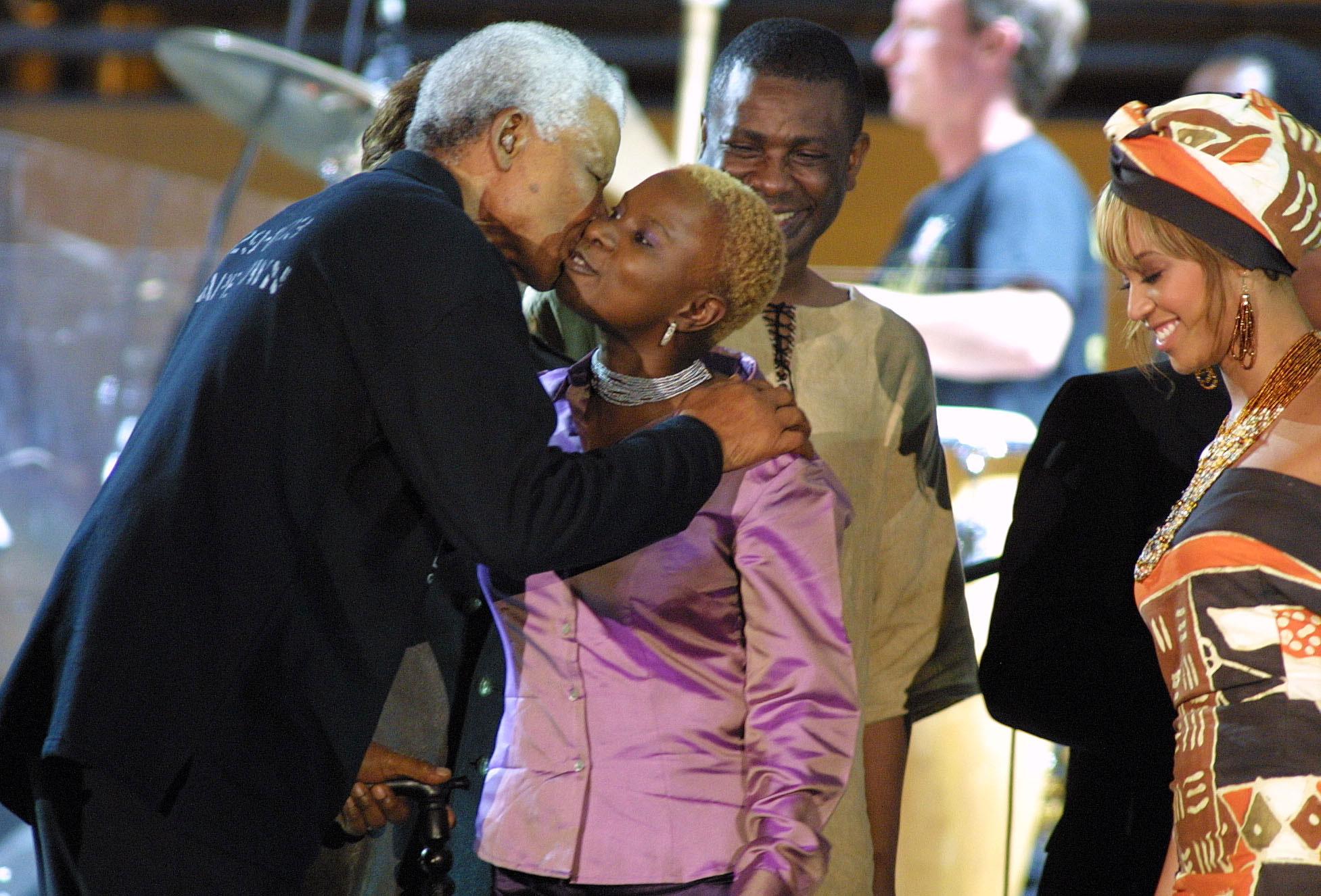 Angélique Kidjo embrassée par Nelson Mandela, le 29 novembre 2003. [AFP - ANNA ZIEMINSKI]