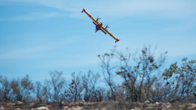 Un Canadair  survole une zone détruite par les flammes à Artigues, en France. [AFP - BERTRAND LANGLOIS]