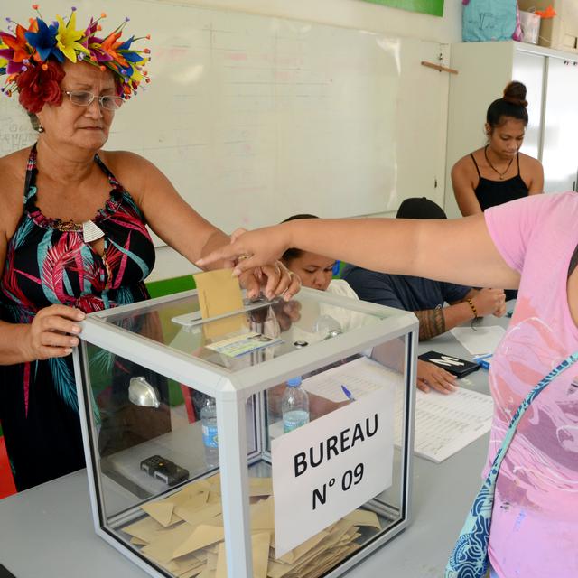 Une votante jette son bulletin dans l'urne d'une station électorale à Tahiti, en Polynésie française. [Mike Leyral]