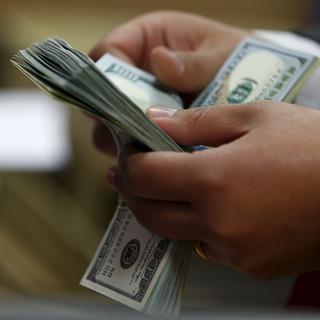 Un homme comptant des billets de dollars américains. [Reuters - Amr Abdallah Dalsh]