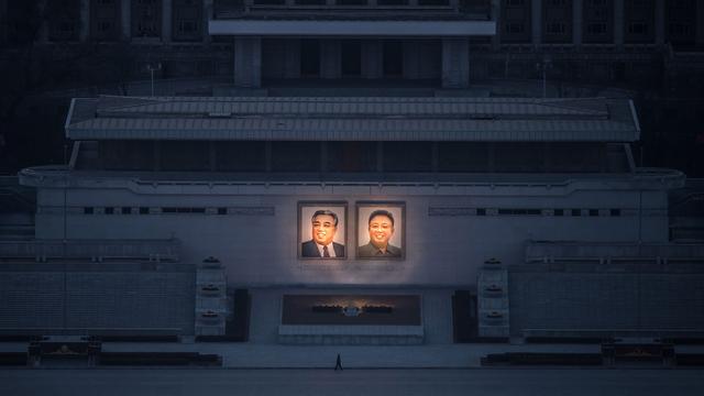 Une personne passe devant les portriats de Kim Il-Sung et Kim Jong-Il à Pyongyang. [AFP - Ed JONES]