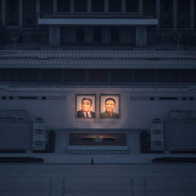 Une personne passe devant les portriats de Kim Il-Sung et Kim Jong-Il à Pyongyang. [AFP - Ed JONES]