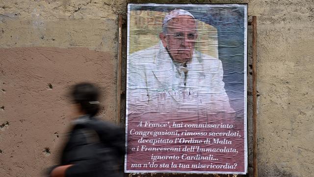 Une des 200 affiches anonymes placardées en ville de Rome pour critiquer le pape François. [AFP - Filippo Monteforte]