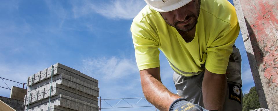 Un maçon sur le chantier d'une maison en construction à Erde (VS). (image d'illustration) [Keystone - Olivier Maire]