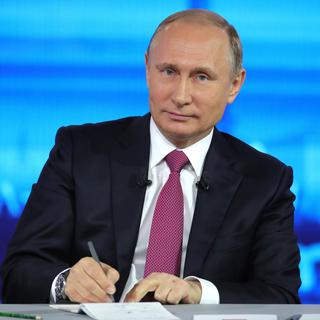 Le président russe Vladimir Poutine prend des notes dans l'émission "Ligne Directe", à laquelle il participe traditionnellement une fois par année. [AFP - Mikhail Klimentyev/Sputnik, Kremlin Pool Photo via AP]
