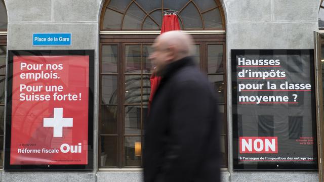 Deux affiches placardées à Fribourg concernant la votation du 12 février sur la RIE III. [Keystone - Thomas Delley]