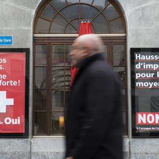 Deux affiches placardées à Fribourg concernant la votation du 12 février sur la RIE III. [Keystone - Thomas Delley]