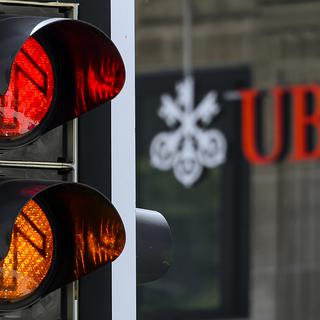 A sign of the Swiss banking giant UBS is seen behind traffic lights on June 7, 2013 in Lausanne. French investigators have placed Swiss bank UBS under formal investigation on suspicion that it tried to persuade rich French clients to open undeclared accounts in Switzerland, a legal source said. The move came less than a week after the French branch of UBS was also placed under investigation -- the closest equivalent in France to being charged. AFP PHOTO / FABRICE COFFRINI
FABRICE COFFRINI / AFP [AFP - Fabrice Coffrini]