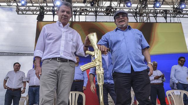 Le guérillero Timochenko (droite) et le président colombien Juan Manuel Santos lors du dépôt des armes des Farc le 27 juin dernier. [AFP - High Commissioner for Peace]