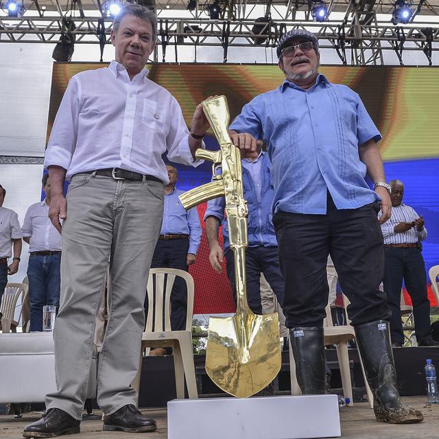 Le guérillero Timochenko (droite) et le président colombien Juan Manuel Santos lors du dépôt des armes des Farc le 27 juin dernier. [AFP - High Commissioner for Peace]