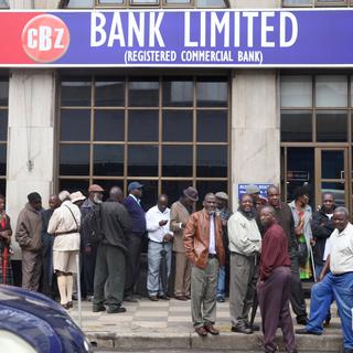 Des personnes font la queue pour retirer de l'argent dans une banque de Harare, au Zimbabwe. [Reuters - Philimon Bulawayo]
