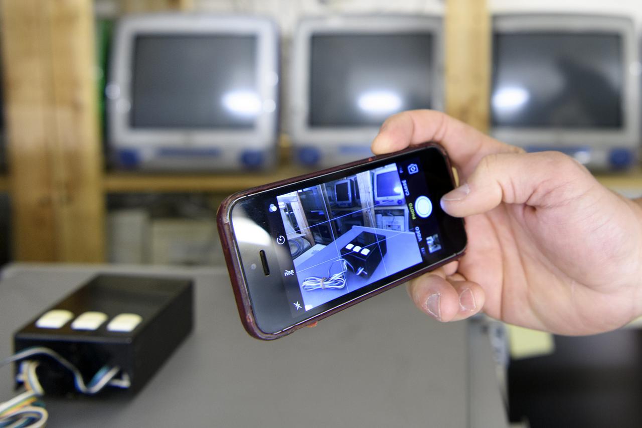 Choc des générations au Musée Bolo : un iPhone qui photographie la première souris (1974) du Laboratoire en micro-informatique de l'EPFL [Keystone - Laurent Gilliéron]