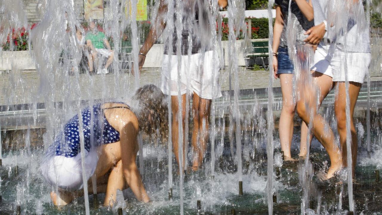 Baignade estivale dans la fontaine de la place de la Riponne à Lausanne. [Keystone - Salvatore Di Nolfi]