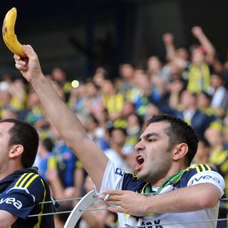 Un supporter brandit une banane alors que l'équipe de Galatasaray arrive. [AFP - Ozan Kose]