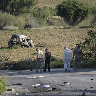 La police et les experts inspectent le lieu de l'explosion de la voiture de la blogueuse maltaise, le 16 octobre 2017. [AFP]