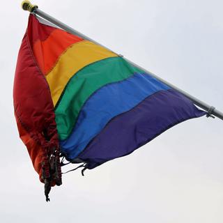 Un drapeau symbole des LGBT partiellement brûlé en signe de lutte contre les crimes homophobes. [keystone - Mark Thiessen]