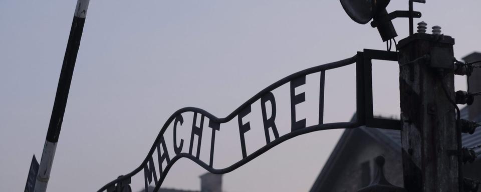 L'entrée du camp de concentration et d'extermination d'Auschwitz-Birkenau et son enseigne "Arbeit macht frei" ("le travail rend libre"). [EPA - Andrzej Grygiel]