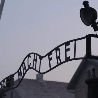 L'entrée du camp de concentration et d'extermination d'Auschwitz-Birkenau et son enseigne "Arbeit macht frei" ("le travail rend libre"). [EPA - Andrzej Grygiel]