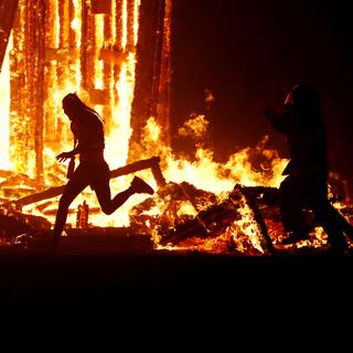 "Course-poursuite devant un brasier", une image dramatique du festival Burning Man. [Reuters - Jim Bourg]