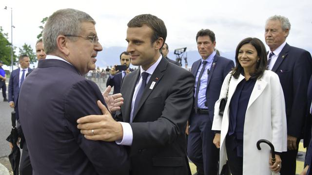 Emmanuel Macron accueilli à Ouchy par le président du CIO Thomas Bach. [AFP - Fabrice Coffrini]