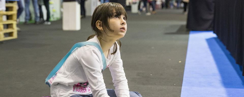 Une enfant en pleine chasse au trésor, lors du Salon du livre 2016. [Keystone - Cyril Zingaro]